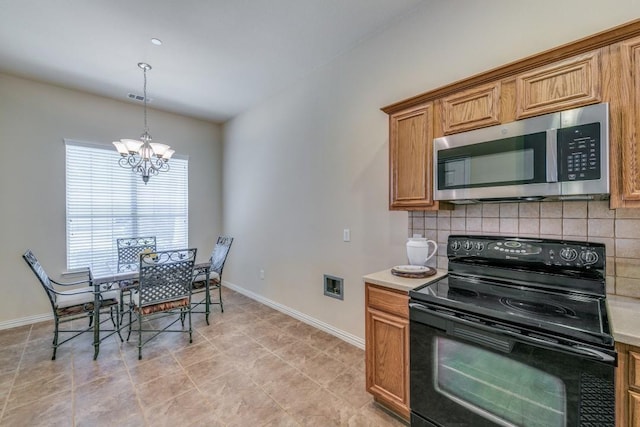 kitchen with decorative light fixtures, electric range, a chandelier, and decorative backsplash