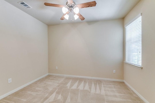 carpeted spare room featuring ceiling fan