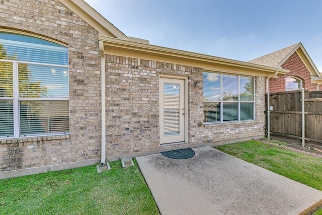 entrance to property with a patio and a yard