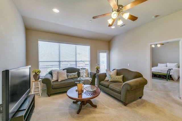 living room with vaulted ceiling, light colored carpet, and ceiling fan