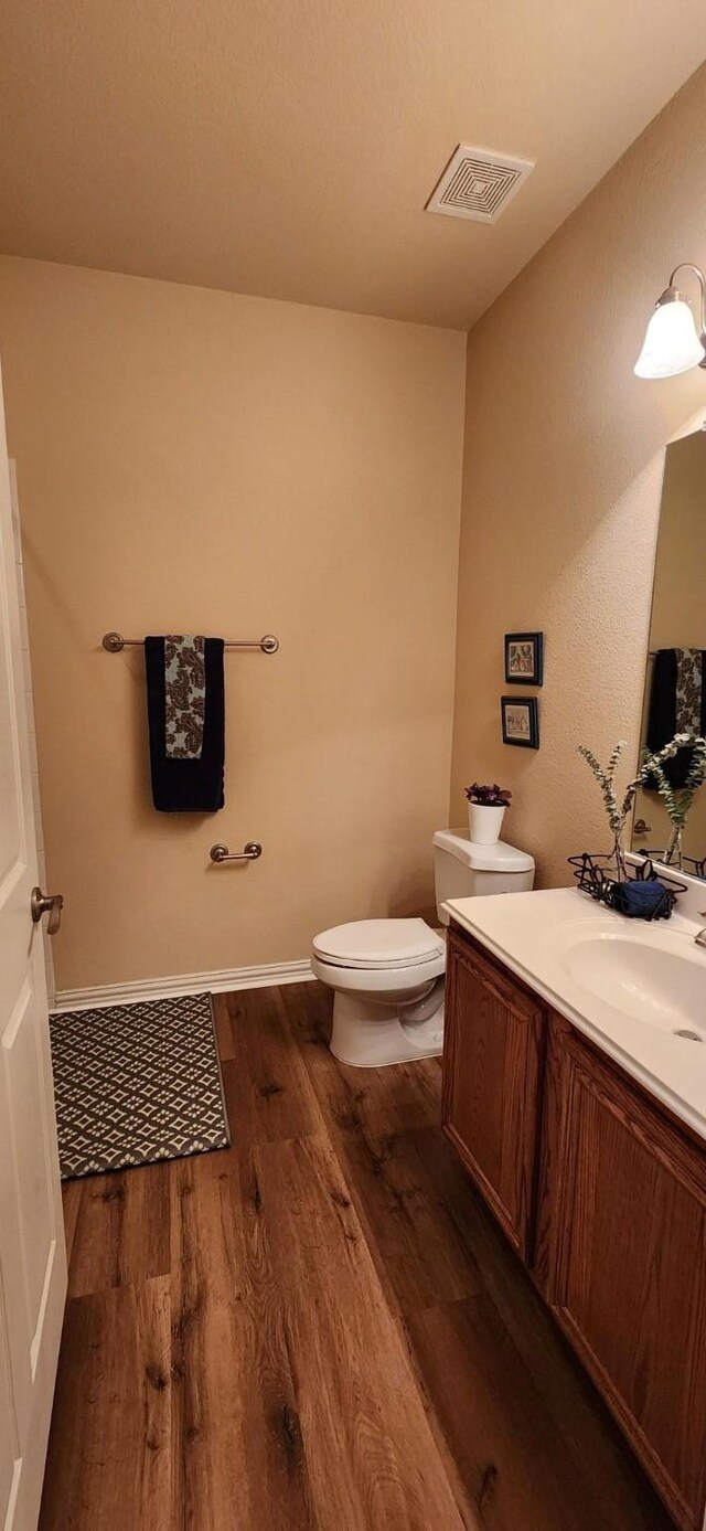 2821 Fordham Rd, Plano, TX 75025 - half bath with wood finished floors, toilet, vanity, and baseboards