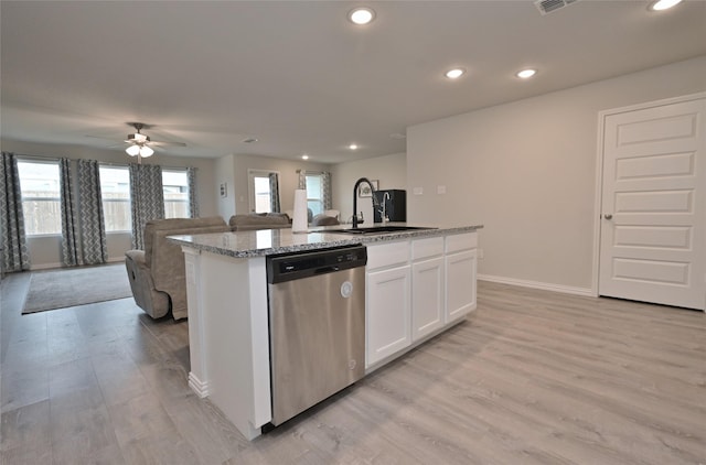 kitchen featuring sink, white cabinetry, stainless steel dishwasher, an island with sink, and light stone countertops