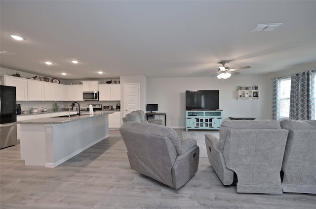 living room with ceiling fan and light hardwood / wood-style floors