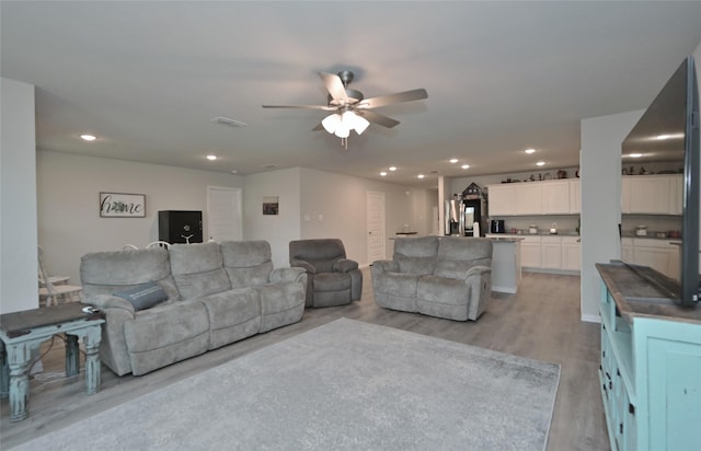 living room with ceiling fan and light wood-type flooring