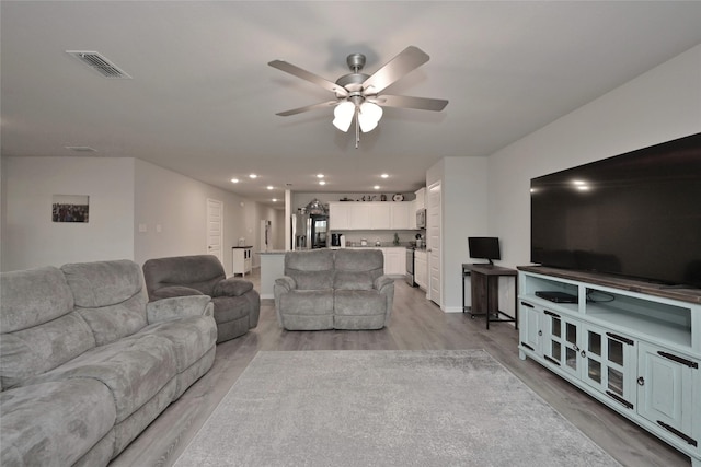 living room with ceiling fan and light hardwood / wood-style floors