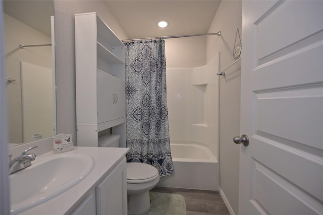 full bathroom featuring wood-type flooring, vanity, shower / tub combo, and toilet