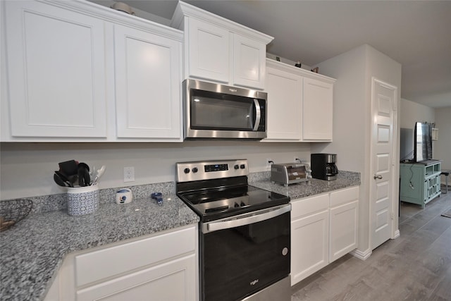 kitchen featuring white cabinetry, appliances with stainless steel finishes, and stone countertops