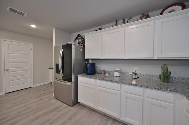 kitchen featuring light hardwood / wood-style flooring, light stone countertops, white cabinets, and stainless steel refrigerator with ice dispenser