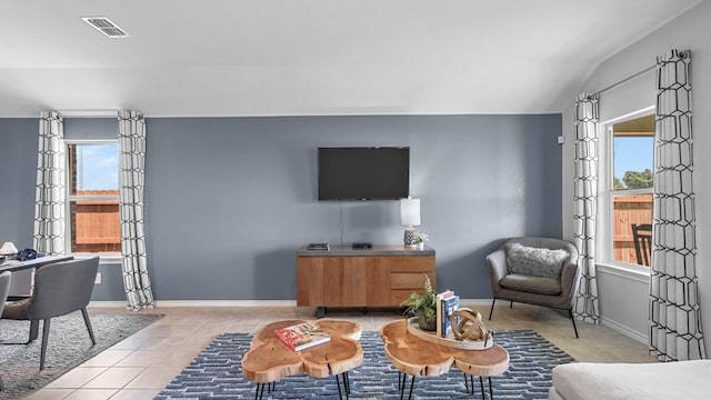 living room featuring light tile patterned flooring, lofted ceiling, and a wealth of natural light