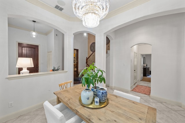 tiled dining area with crown molding and an inviting chandelier