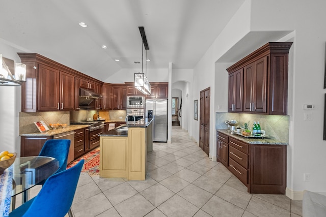 kitchen featuring a center island, vaulted ceiling, hanging light fixtures, light tile patterned floors, and appliances with stainless steel finishes