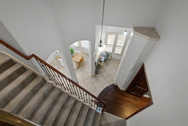 stairs with a high ceiling and tile patterned floors