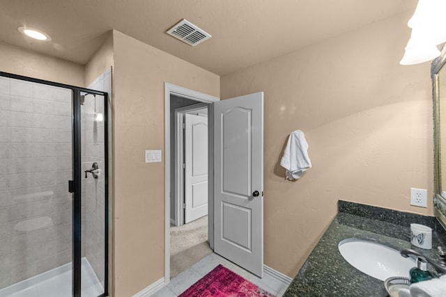 bathroom featuring vanity, a shower with shower door, and tile patterned floors