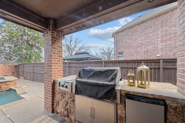 view of patio featuring area for grilling, a gazebo, and an outdoor kitchen