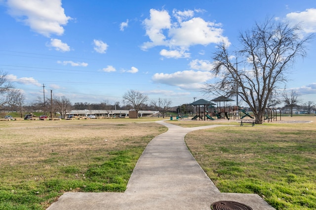 view of property's community with a playground and a yard