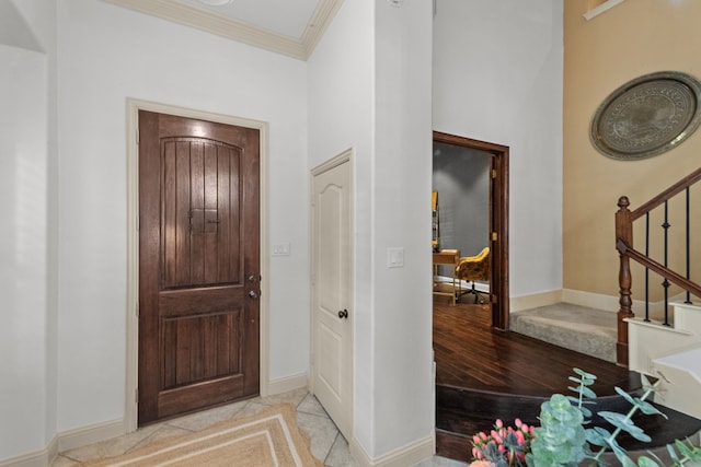 foyer entrance with crown molding and light hardwood / wood-style flooring