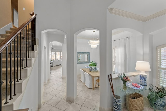 interior space featuring light tile patterned floors, crown molding, and a high ceiling