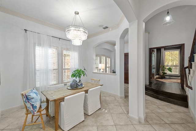 dining space with crown molding, light tile patterned flooring, and an inviting chandelier