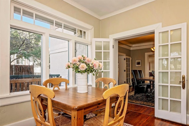 dining space featuring dark hardwood / wood-style flooring, crown molding, and french doors