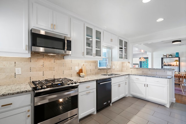 kitchen featuring sink, kitchen peninsula, stainless steel appliances, light stone countertops, and white cabinets