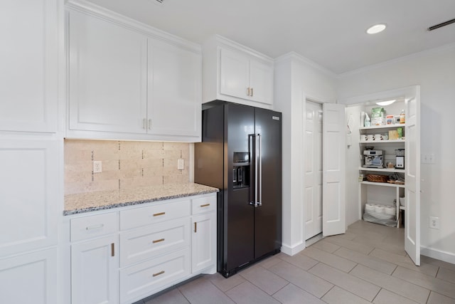 kitchen with white cabinets, decorative backsplash, high end black fridge, ornamental molding, and light stone counters