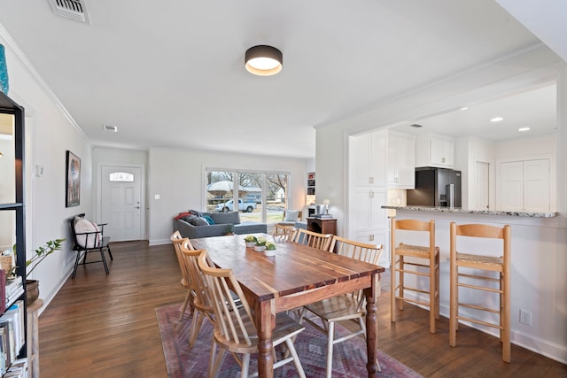 dining room with crown molding and dark hardwood / wood-style flooring