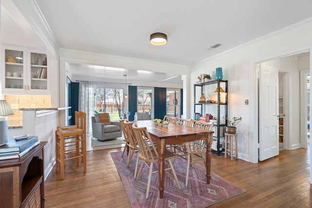 dining space with crown molding and dark hardwood / wood-style floors