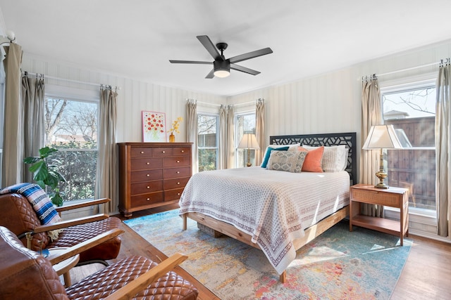 bedroom with hardwood / wood-style flooring, ceiling fan, and multiple windows