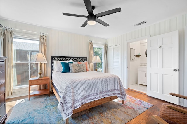 bedroom with hardwood / wood-style floors, ceiling fan, and ensuite bathroom