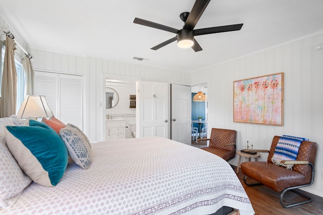 bedroom with ceiling fan, ensuite bath, crown molding, and hardwood / wood-style floors