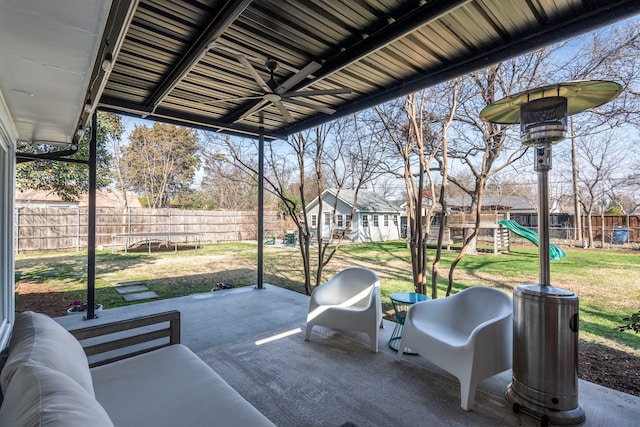 view of patio featuring an outbuilding, ceiling fan, a playground, and a trampoline