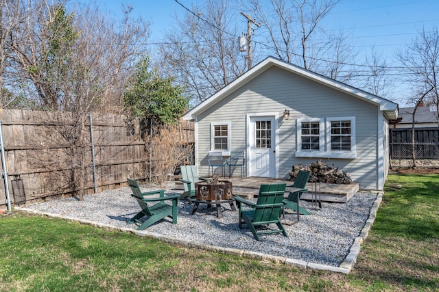 back of property featuring a yard and a fire pit