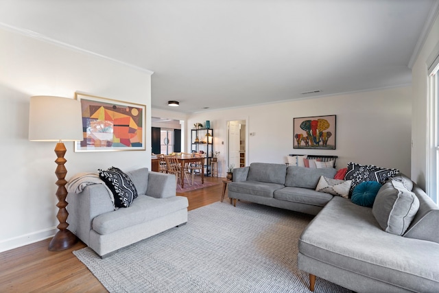 living room with wood-type flooring and ornamental molding