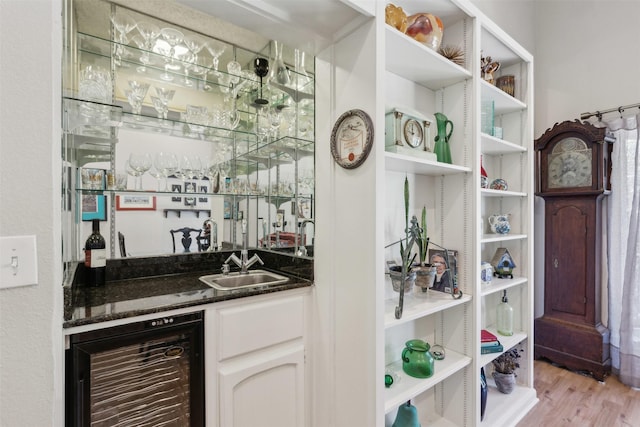 bar with wine cooler, sink, light hardwood / wood-style floors, and white cabinets