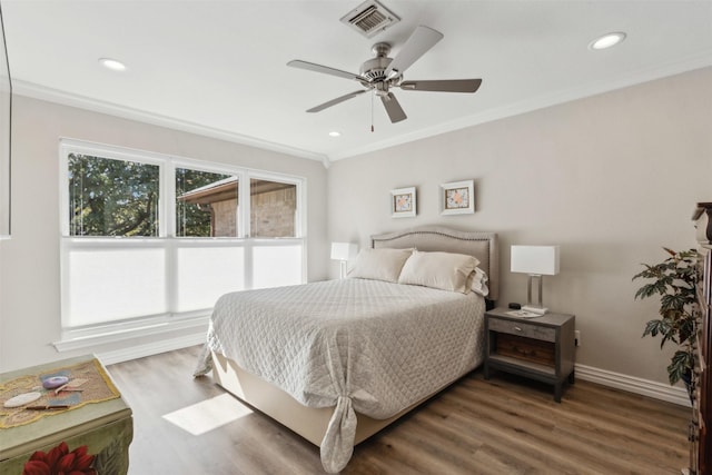 bedroom featuring dark wood-type flooring, ornamental molding, and ceiling fan