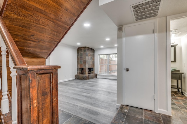 interior space with wood ceiling, ornamental molding, a fireplace, and dark hardwood / wood-style flooring