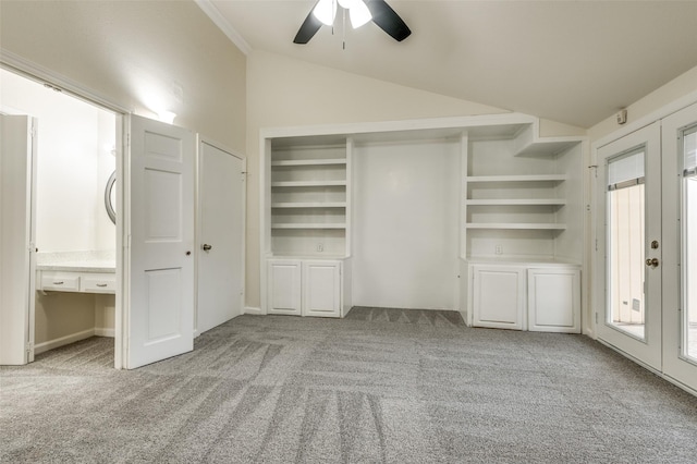 unfurnished bedroom featuring vaulted ceiling, ornamental molding, ceiling fan, light carpet, and french doors