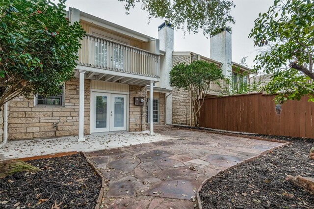 rear view of property featuring a patio, french doors, and a balcony