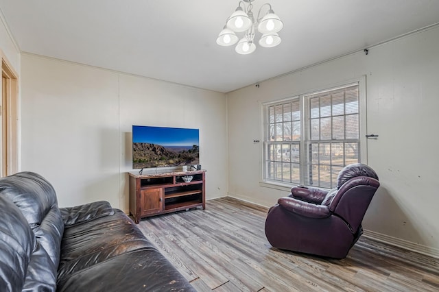 living area with light wood-style floors, baseboards, and an inviting chandelier