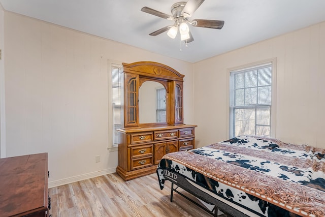 bedroom with ceiling fan, light wood-type flooring, and baseboards