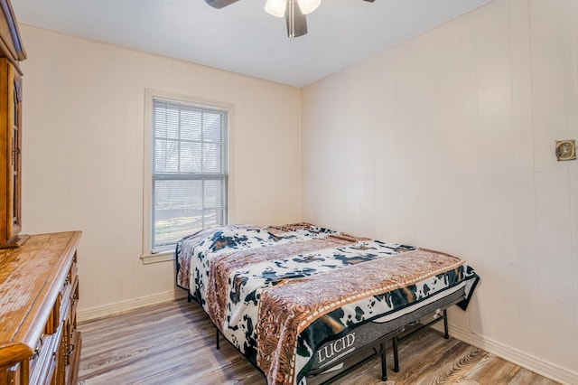 bedroom featuring ceiling fan, light wood-style flooring, and baseboards