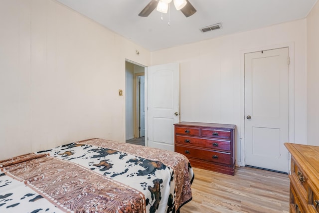 bedroom featuring a ceiling fan, visible vents, and light wood-style flooring