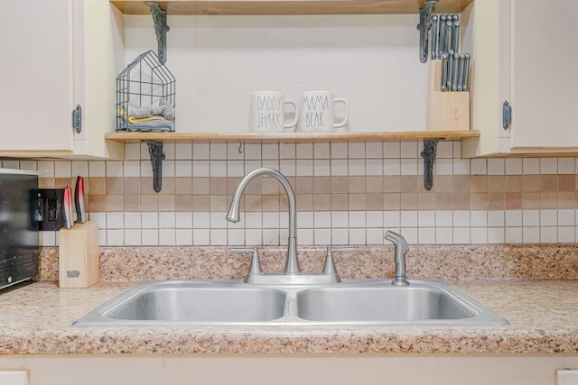 details with backsplash, a sink, and white cabinetry