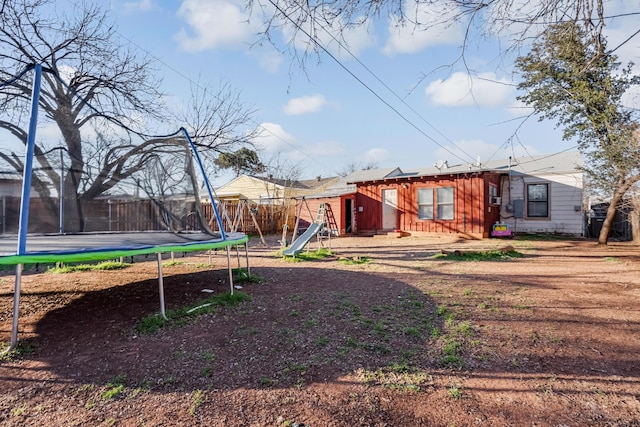 view of yard featuring a playground and a trampoline