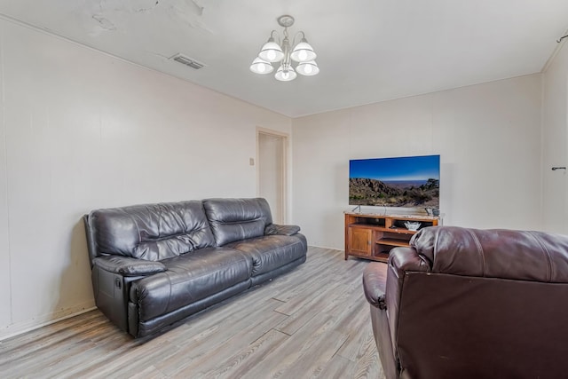 living room with light hardwood / wood-style floors and a chandelier