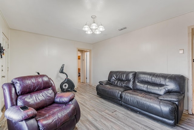 living room with light wood-type flooring, visible vents, and a notable chandelier