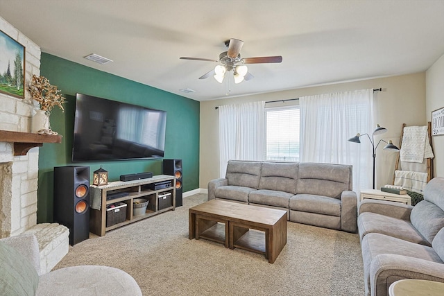 carpeted living room featuring a fireplace and ceiling fan