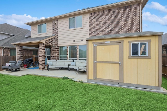 back of house with a patio, outdoor lounge area, a yard, and a storage shed