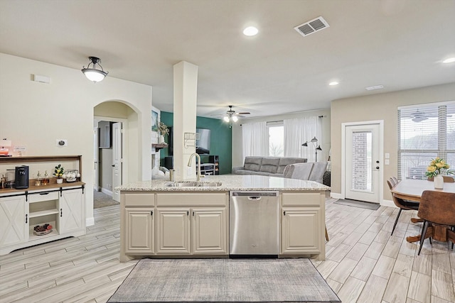 kitchen featuring light stone counters, sink, a wealth of natural light, and stainless steel dishwasher