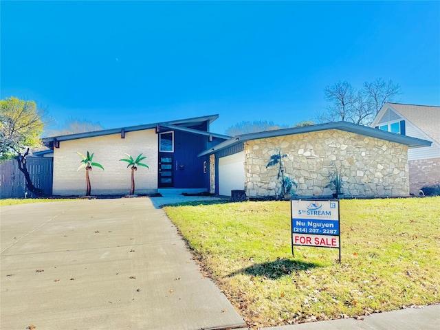 view of front of home featuring a garage and a front lawn